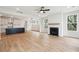 Bright living room featuring hardwood floors, a modern fireplace, and seamless kitchen access at 126 Cantona Dr, Summerville, SC 29483