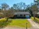 Birds-eye view of a brick home with mature trees, a green lawn, and a paved driveway at 1423 Fairfield Ave, Charleston, SC 29407