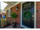 Charming front door with a wreath, potted plants, and a classic brick exterior at 1423 Fairfield Ave, Charleston, SC 29407