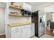 Bright kitchen with stainless refrigerator, floating wood shelves, white cabinets and butcher block counters at 1423 Fairfield Ave, Charleston, SC 29407