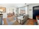 Open-concept living room featuring hardwood floors, a gray sofa, and an archway leading to the dining room at 1423 Fairfield Ave, Charleston, SC 29407