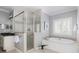 Bright bathroom featuring shower with glass door, soaking tub, and neutral decor at 1464 Dupree Creek Rd, Awendaw, SC 29429