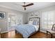 Cozy bedroom with wood floors, decorative ceiling fan, and access to a screened porch at 1464 Dupree Creek Rd, Awendaw, SC 29429