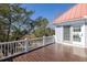 Deck with railing showcasing the home's setting among beautiful mature trees at 1464 Dupree Creek Rd, Awendaw, SC 29429