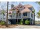 Charming coastal home featuring a unique red roof, elevated design, and lush landscaping, embodying luxury waterfront living at 1464 Dupree Creek Rd, Awendaw, SC 29429