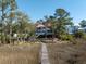 Charming coastal home with a red roof, spacious deck, and private access to the water at 1464 Dupree Creek Rd, Awendaw, SC 29429