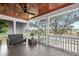 Relaxing screened-in porch boasts wood ceiling, tiled floors, seating, and serene views at 1464 Dupree Creek Rd, Awendaw, SC 29429