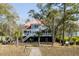 A picturesque view of a two-story home with a red roof and spacious decks, nestled among lush greenery at 1464 Dupree Creek Rd, Awendaw, SC 29429