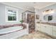 This bathroom features a garden tub, stand-up shower with ornate tile and double sinks with a granite countertop at 1543 Wando Landing St, Charleston, SC 29492
