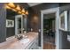 A half bath with gray walls, marble countertop and ornate mirror, leading to a bedroom with a drum set at 1543 Wando Landing St, Charleston, SC 29492