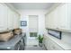 Laundry room with cabinets, washer and dryer, potted plant, and gray, black and white patterned rug at 1543 Wando Landing St, Daniel Island, SC 29492