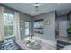 Living room with gray walls, tile floors, black leather couch and a glass coffee table surrounded by art at 1543 Wando Landing St, Daniel Island, SC 29492