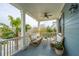 Outdoor porch with wicker couches, columns, palm trees, and a ceiling fan, creating an inviting space at 1543 Wando Landing St, Charleston, SC 29492