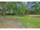 Large backyard featuring a mix of grassy areas, mature trees, and a wooden fence for privacy at 1563 Traywick Ave, Johns Island, SC 29455