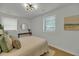 Bright bedroom featuring a neutral palette, wood floors, modern light fixture, and round mirror at 1563 Traywick Ave, Johns Island, SC 29455
