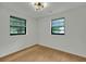 Bright bedroom featuring a neutral palette, wood floors, modern light fixture, and windows at 1563 Traywick Ave, Johns Island, SC 29455