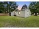 Rear exterior view of home and screen patio with landscaped yard at 1563 Traywick Ave, Johns Island, SC 29455