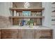 Stylish bar area with wooden shelves, marble countertop, custom cabinets, and decorative backsplash at 1714 Middle St, Sullivans Island, SC 29482