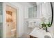 Bright bathroom featuring patterned tile, a toilet and cabinet, and vanity with flowers at 1714 Middle St, Sullivans Island, SC 29482