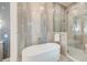 Luxurious bathroom with an oval freestanding tub and glass shower featuring gold fixtures at 1714 Middle St, Sullivans Island, SC 29482