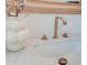 Close up on a bright white sink with marble countertops, gold faucet, and decorative vase at 1714 Middle St, Sullivans Island, SC 29482