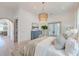 Serene bedroom features a decorative chandelier, blue dresser, and access to a private balcony at 1714 Middle St, Sullivans Island, SC 29482