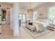 Bright bedroom with wood floors, a large bed, a patterned rug, and a view into a luxury bathroom at 1714 Middle St, Sullivans Island, SC 29482