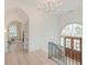 Bright foyer featuring hardwood floors, modern chandelier, and arched doorways at 1714 Middle St, Sullivans Island, SC 29482