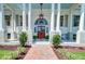 Elegant home exterior featuring a brick walkway, columned porch, and manicured landscaping at 1714 Middle St, Sullivans Island, SC 29482