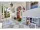 Inviting front porch with checkered tile, outdoor seating, and elegant double doors at 1714 Middle St, Sullivans Island, SC 29482