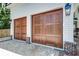 Attached two-car garage with elegant stained wood doors and brick paver driveway at 1714 Middle St, Sullivans Island, SC 29482