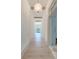 Long hallway with hardwood floors, two chandeliers and view of a front door at 1714 Middle St, Sullivans Island, SC 29482