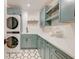 Bright laundry room with pale blue cabinets, modern appliances, white countertops, and geometric floor tiles at 1714 Middle St, Sullivans Island, SC 29482