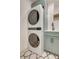 Stackable washer and dryer set in a laundry room with blue cabinets and geometric floor tiles at 1714 Middle St, Sullivans Island, SC 29482