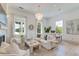 Inviting living area featuring comfortable seating, stylish chandelier, fireplace, and large windows at 1714 Middle St, Sullivans Island, SC 29482