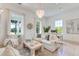 Bright living room with wood floors, chandelier, large windows, and comfortable seating at 1714 Middle St, Sullivans Island, SC 29482