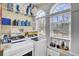 Bright laundry room with large windows, washer, dryer, storage shelves, and overhead cabinets at 1739 Indigo Island Dr, Hanahan, SC 29410