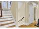 A staircase with wood steps and white risers, showcasing architectural details and natural light from a window at 1739 Indigo Island Dr, Hanahan, SC 29410