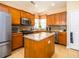 Well-lit kitchen featuring stainless steel appliances, a granite island, and wood cabinets at 192 Sea Lavender Ln, Summerville, SC 29486