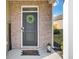 Inviting front porch featuring a wreath-adorned door, 'Welcome' mat, and brick accents at 202 N Light Way, Summerville, SC 29486