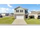 Traditional home exterior boasts a two-car garage, well-kept lawn, and inviting curb appeal on a sunny day at 202 N Light Way, Summerville, SC 29486