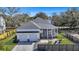 Aerial view showcasing the home's three-car garage, screened porch and well manicured yard at 2028 Ironstone Aly, Charleston, SC 29407