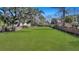 Expansive backyard featuring lush green lawn and brick perimeter walls, with mature trees at 2028 Ironstone Aly, Charleston, SC 29407