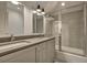 Modern bathroom features a double sink vanity, a glass enclosed shower-tub, and stylish lighting fixtures for a spa-like experience at 2028 Ironstone Aly, Charleston, SC 29407