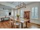 Well-lit dining room with wooden table, light fixture, and white shutters, flowing into the bright living room at 2028 Ironstone Aly, Charleston, SC 29407