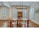 Elegant dining room with hardwood floors, white walls, and modern light fixture above a wood dining table with seating at 2028 Ironstone Aly, Charleston, SC 29407