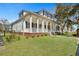 Charming home with a large porch, white columns, black shutters, and a lush green lawn at 2028 Ironstone Aly, Charleston, SC 29407