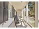 Relaxing front porch view with black rocking chairs, shutters, and ample space for outdoor enjoyment at 2028 Ironstone Aly, Charleston, SC 29407