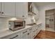 Modern white kitchen featuring stainless steel appliances, sleek countertops, and ample cabinet space at 2028 Ironstone Aly, Charleston, SC 29407