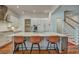 Bright kitchen island with stainless appliances, leather barstools and white cabinets adjacent to the stairs at 2028 Ironstone Aly, Charleston, SC 29407